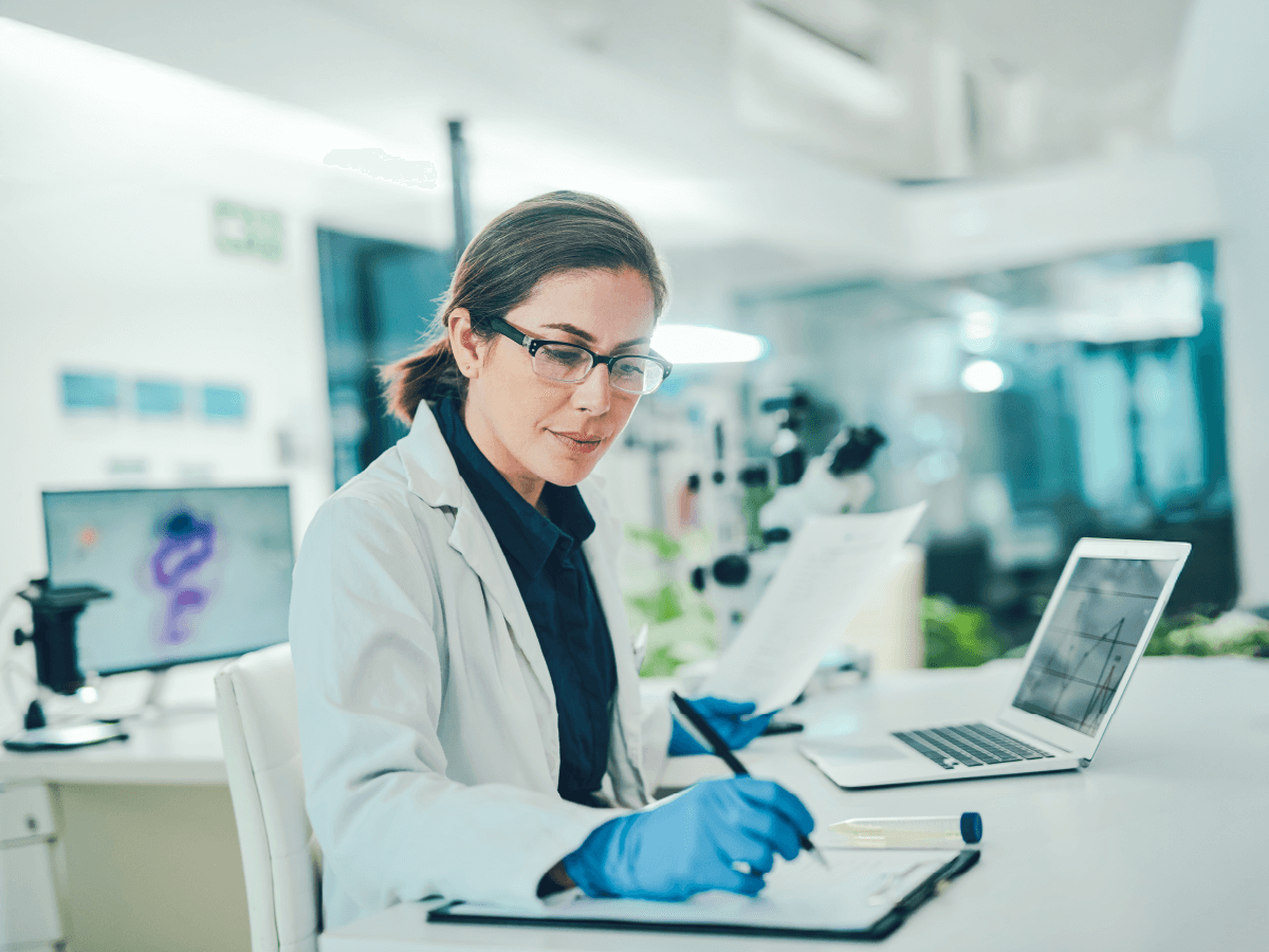 scientist in lab coat taking notes